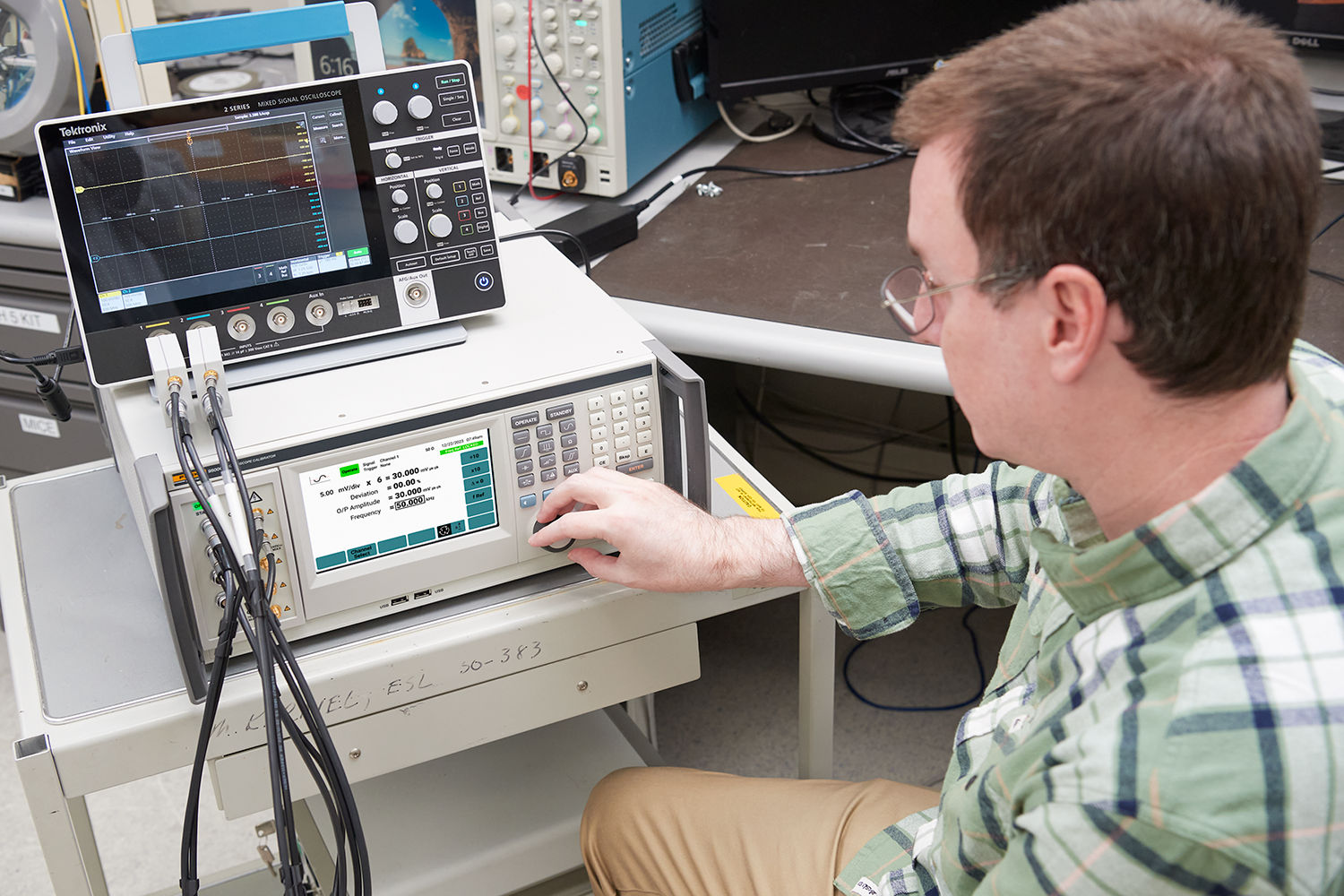 Imagem de um técnico configurando a calibração do osciloscópio Fluke 9500C